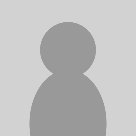 A modern red brick house with a garage to the right and a drive with trees on the left